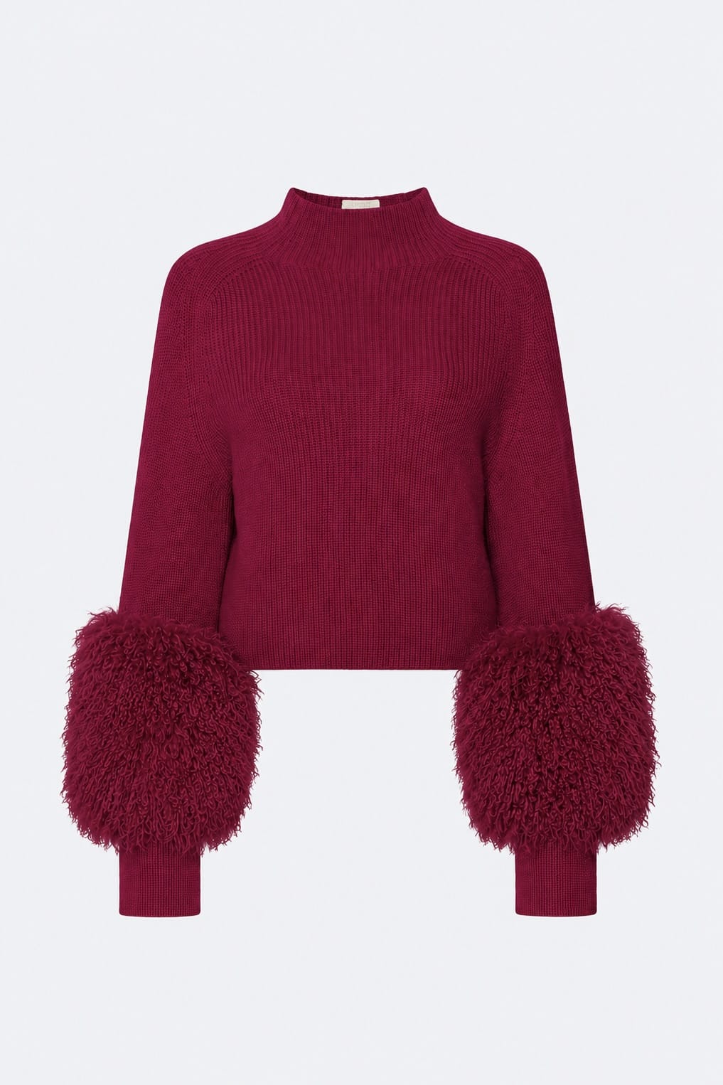 A deep magenta ribbed knit mock-neck sweater with voluminous, fluffy faux-fur pom-pom cuffs, shown against a plain light gray background.